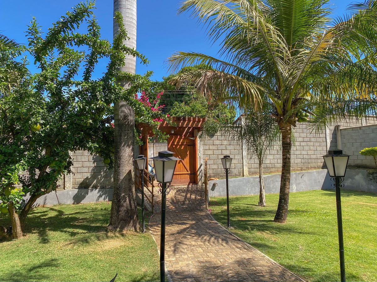 Caminho de pedra entre jardins até o portão